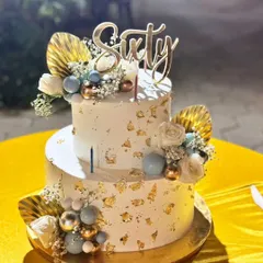 Celebrating sixty! This elegant two-tier cake with gold leaf, delicate flowers, and a "Sixty" topper was perfect for a milestone birthday. We ensure our cakes are delivered safely across Bangalore for your special events.