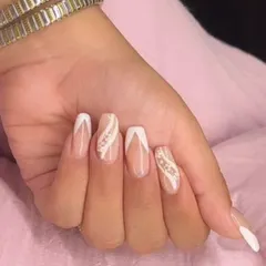 An elegant design featuring a white V-shaped French tip, complemented by accent nails with a delicate swirl of glitter.