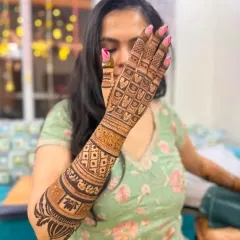 This design showcases a variety of textures, from the bold lotus motifs at the top to the fine jaal pattern covering the hand.