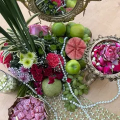 An overhead view of our 'Bagh-e-Ishq' tablescape, featuring a lush mix of fruits, flowers, pearls, and traditional sweets for a Mehendi ceremony.