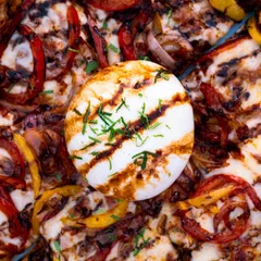 A top-down shot of the burrata pizza, showing the beautiful arrangement of colors from the peppers and the perfectly grilled cheese. Great for menus.