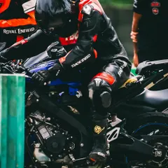 A rider making final adjustments before heading out onto the track. I teach my students to be in tune with their machines, understanding the importance of proper setup and pre-ride checks.