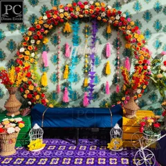 Another perspective of the vibrant Mehndi stage, showing the deep blue seating and the purple patterned floor that complements the colorful decor perfectly.