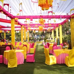 A full view of the Haldi seating area in Lonavala. We used bright yellow and pink chair covers and tablecloths under a tent of colorful drapes to create a completely immersive and festive environment.