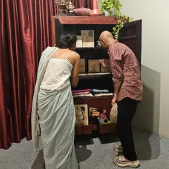 A moment of discovery at our exhibition. We design spaces that invite curiosity, like this antique cabinet filled with smaller artworks and objects, encouraging visitors to look closer and engage with the narrative on an intimate level.