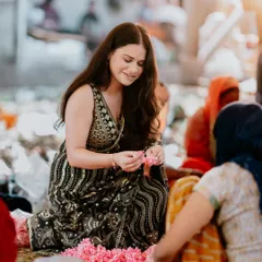 A beautiful, candid shot of the bride interacting with flower sellers at the market. This photo is rich with story and authentic emotion.
