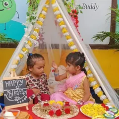 Two little girls celebrate Rakhi in our decorated tent, sharing sweets and celebrating the bond of siblinghood.
