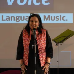 A participant delivering her poem with passion and poise at the showcase event. We teach you how to use your voice and presence to make your words resonate.