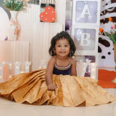 A joyful shot showcasing the full volume and beautiful drape of the golden silk brocade lehenga. The design ensures that the child is comfortable and can move freely, making it perfect for long events and festive fun.