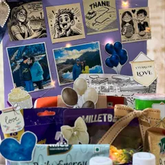 A closer look at the personalized elements of the anniversary hamper. The custom illustrations and photos are lit with delicate fairy lights, creating a romantic and visually stunning centerpiece for the gift.