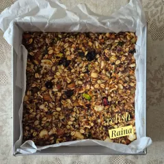 This is a full tray of my granola mixture before it's cut into bars. It's a wholesome blend of rolled oats, nuts, seeds, and dried fruits, ready to be baked.