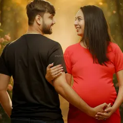 A candid glance shared between the expecting couple during their outdoor photoshoot. These unscripted moments capture the genuine love and anticipation.
