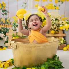 Pure joy! This baby is having the time of her life playing with the rubber ducks in her sunny, lemon-themed milk bath.
