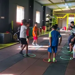 Kids participating in a group fitness game using agility rings. Making fitness fun is key to keeping them engaged.
