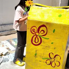 A child carefully paints a prop for the school play. This multidisciplinary project integrated art, literature, and performance, showing how learning can be deeply interconnected.