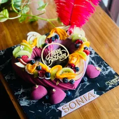 Indulge in elegance with our classy lavender cake, adorned with exotic fruits. This heart-shaped entremet cake is perfect as a centerpiece for a sophisticated dessert spread.