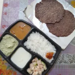 A wholesome South Indian meal featuring two Ragi Rottis (finger millet bread), coconut chutney, steamed rice, sprouts sambar, fresh curd, pickle, and cut fruits.