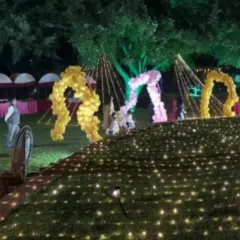 We can spell out any name or message in a big way with these custom balloon structures. This large outdoor setup features the name 'RAVI' in giant balloon letters, set on a lawn illuminated by hundreds of ground lights for a stunning effect.