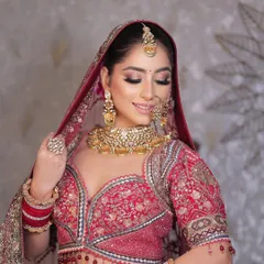 The perfect bridal pose. This look showcases a classic red lehenga with soft, shimmery eye makeup and a flawless base, creating a radiant and traditional aesthetic.