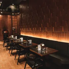 The warm and inviting interior of our Forum Kanakapura Road outlet, featuring our signature brick walls, terracotta tiles, and a glowing wood-fired oven.