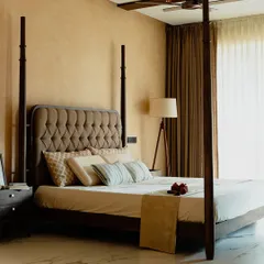 A bedroom should be a personal sanctuary. This custom four-poster bed, crafted from rich, dark wood with an elegant tufted headboard, serves as the centerpiece for a truly luxurious and restful retreat.