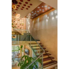 The staircase at Svamitva Terravana is a sculptural element, with a skylight and terracotta pots embedded in the ceiling. This feature brings dappled light into the core of the house, creating a dynamic play of light and shadow.