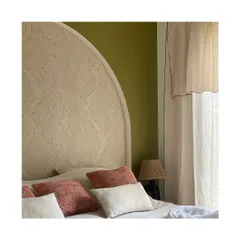 Wallpapers can be used in wonderfully creative ways, such as on this custom headboard. The 'Edge' wallpaper in a soft beige adds texture and a unique, architectural detail to this serene bedroom.