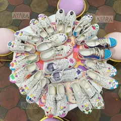 A table full of custom-painted sneakers from a 10th birthday party. This unique and interactive activity allowed each guest to express their creativity and take home a personalized party favor.