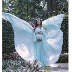 An angelic maternity photo. This powder blue gown with its wing-like trail creates a magical, ethereal look for a mom-to-be in a beautiful garden setting.