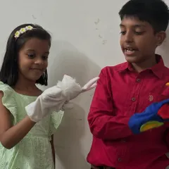 Two students engage in a bit of puppet theatre with the characters they just created. This kind of play is excellent for developing communication, collaboration, and storytelling skills.