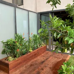 The finished wooden deck and integrated planter box, filled with a mix of flowering and foliage plants, creating a seamless look.