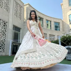 A happy bride twirling in her elegant white lehenga. The pre-draped saree style is both modern and comfortable, perfect for a day event.