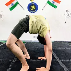 A student works on his Chakrasana, or wheel pose. This is an excellent asana for improving spinal flexibility and opening up the chest and shoulders.
