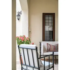I furnished the outdoor deck with a set of black metal armchairs and a sofa, which ties in with the iron railing details used inside the home. Layered with patterned cushions and surrounded by plants, it's the perfect place to unwind.