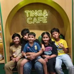 A group of older kids takes a break from playing to hang out and enjoy some treats at the Tinga Cafe.