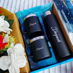 A sleek and modern personalized drinkware set. This gift box includes a matte black temperature bottle and two matching stainless steel mugs, all customized with the name "Deepesh" in an elegant script.