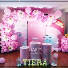 Another view of the pink-themed party setup, showing the "TIERA" marquee lights and decorative props like a mini Ferris wheel and bird cages.