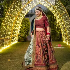 The full glory of this velvet bridal lehenga, captured under beautiful lighting. The fairy lights in the background add to the magical feel of a wedding night.