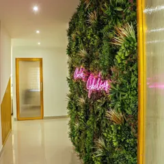 A perfect fusion of modern trends and natural aesthetics. We installed a lush, multi-layered green wall and integrated a custom pink neon sign for a chic and stylish look in this commercial space.