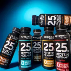 This group shot of Epigamia's protein milkshakes uses a bold blue background and dramatic lighting. The arrangement of the bottles creates a powerful visual that showcases the different flavors in the range.