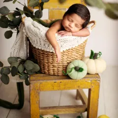 This little pumpkin is sleeping so soundly in a rustic basket. I use props like this vintage yellow chair and soft felted pumpkins to create a warm, autumnal feel for the portrait.