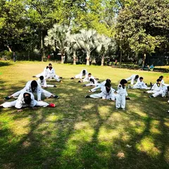 A wide shot of our students during a group stretching session at an outdoor belt test. Discipline and unity are visible even in warm ups.