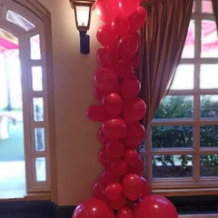 A close-up of a modern, organic-style balloon column in a striking all-red color scheme. This type of arrangement adds height and a dramatic pop of color to any corner of a room or entrance.