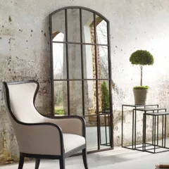 This grand, arched window-pane mirror serves as a stunning architectural feature in this living space. We crafted it to create an illusion of space and light, using a rustic metal frame for a classic, industrial-loft feel. We build large-scale statement mirrors to your exact dimensions.