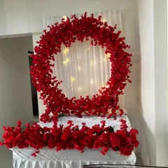 This "Sirf Laal Ishq" setup features a complete ring of vibrant red flowers against a white curtain with fairy lights. The base is also covered in red flowers, creating a bold and passionate statement piece for any event.