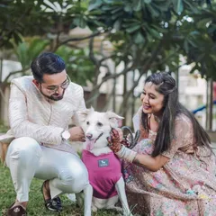 A heartwarming photo of a couple petting their happy dog, who is sitting between them. This image perfectly captures the love and bond they share with their furry family member.