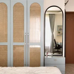 This elegant wardrobe features rattan panels framed in a calming powder blue, accentuated by handmade brass handles. It's a beautiful example of how storage can be a statement piece.