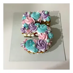 A monogram cake in the shape of the number 5. This strawberry-flavored cake is decorated with beautiful pastel-colored rosettes, perfect for a 5th birthday.