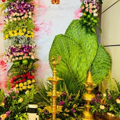A beautiful corner decoration featuring a mix of colorful flowers, woven palm leaves, and traditional brass lamps. These small touches help create a complete and festive atmosphere.
