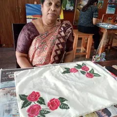 Ms. Sevanjali proudly displays her hand-painted cushion cover from our fabric painting class. Learning to paint on fabric opens up a whole new world of creative possibilities for home decor.